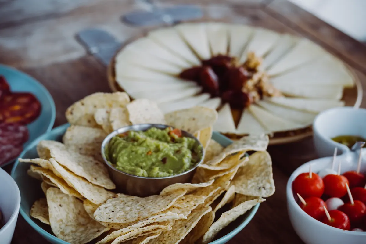 Aperitif served on board the sailboat: cheese, guacamole and snacks