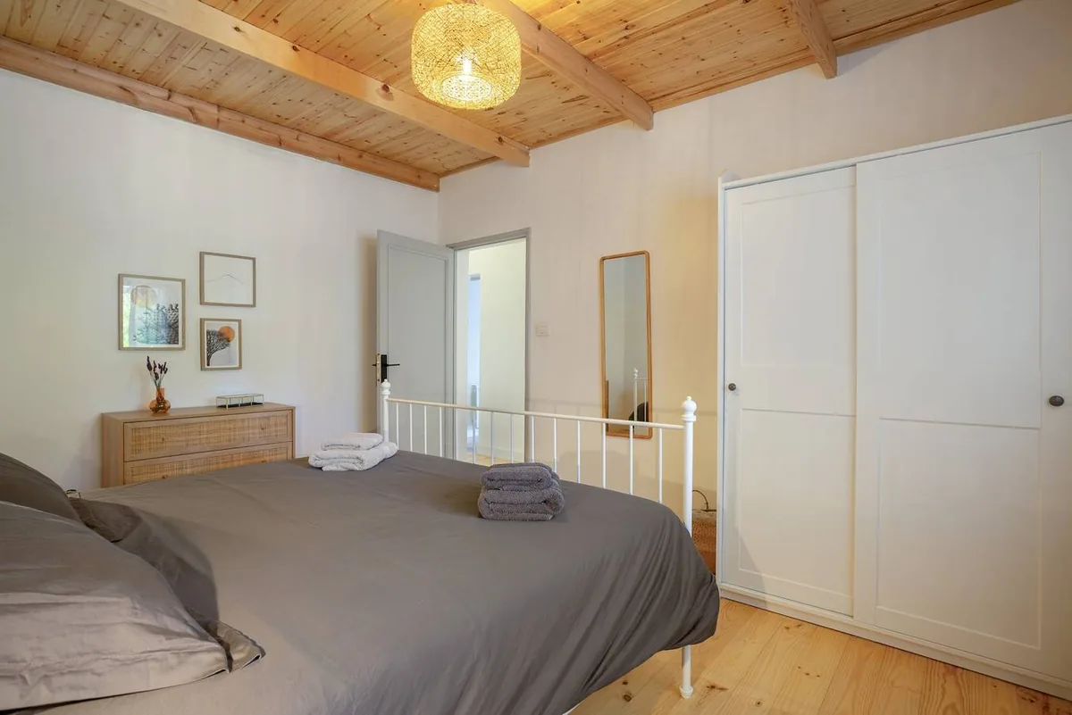 Chambre principale de Picarus Home avec lit double, armoire encastrée et plafond en bois