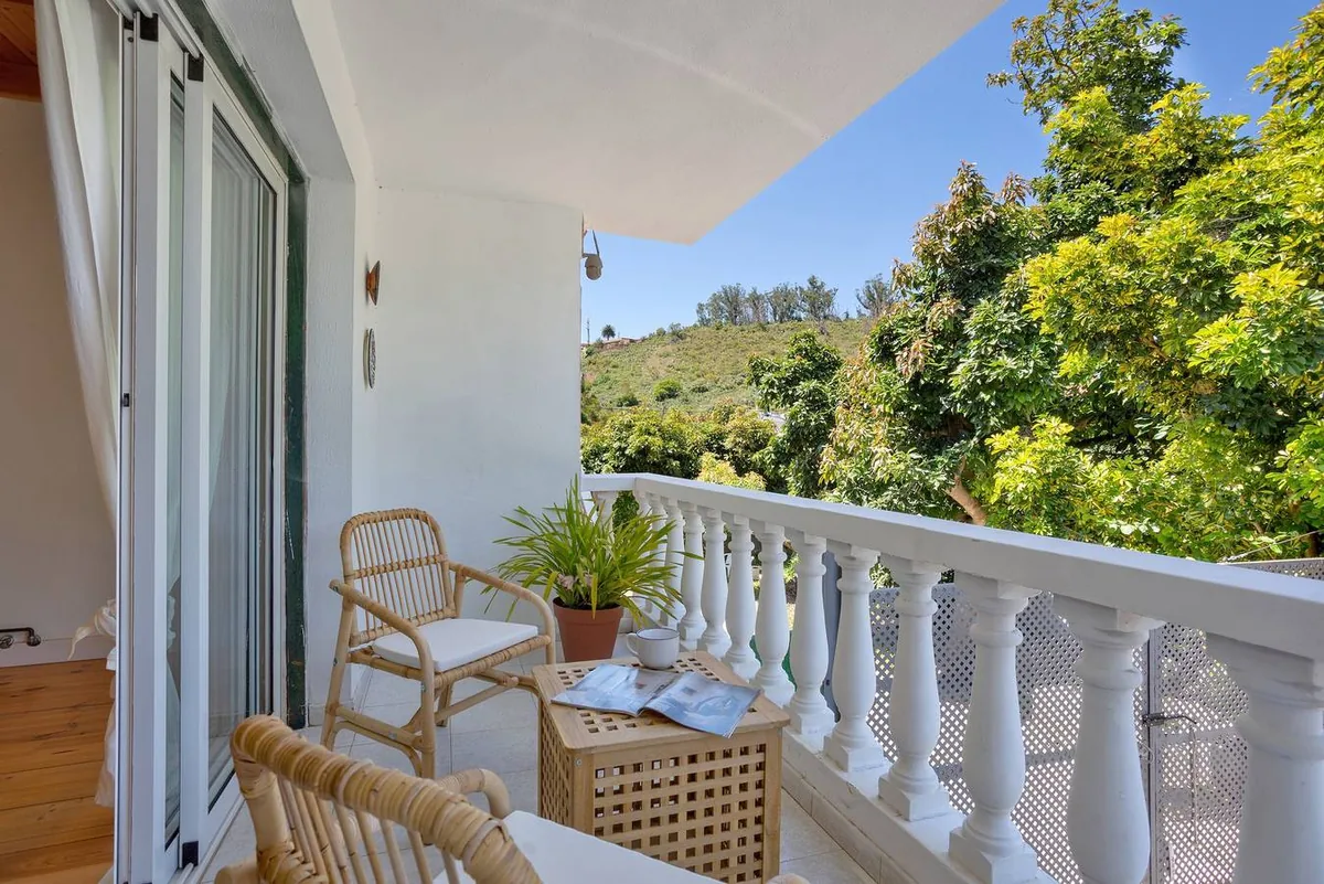 Terrasse à balustrade blanche de Picarus Home, avec une table dressée et la végétation du nord de Tenerife en fond